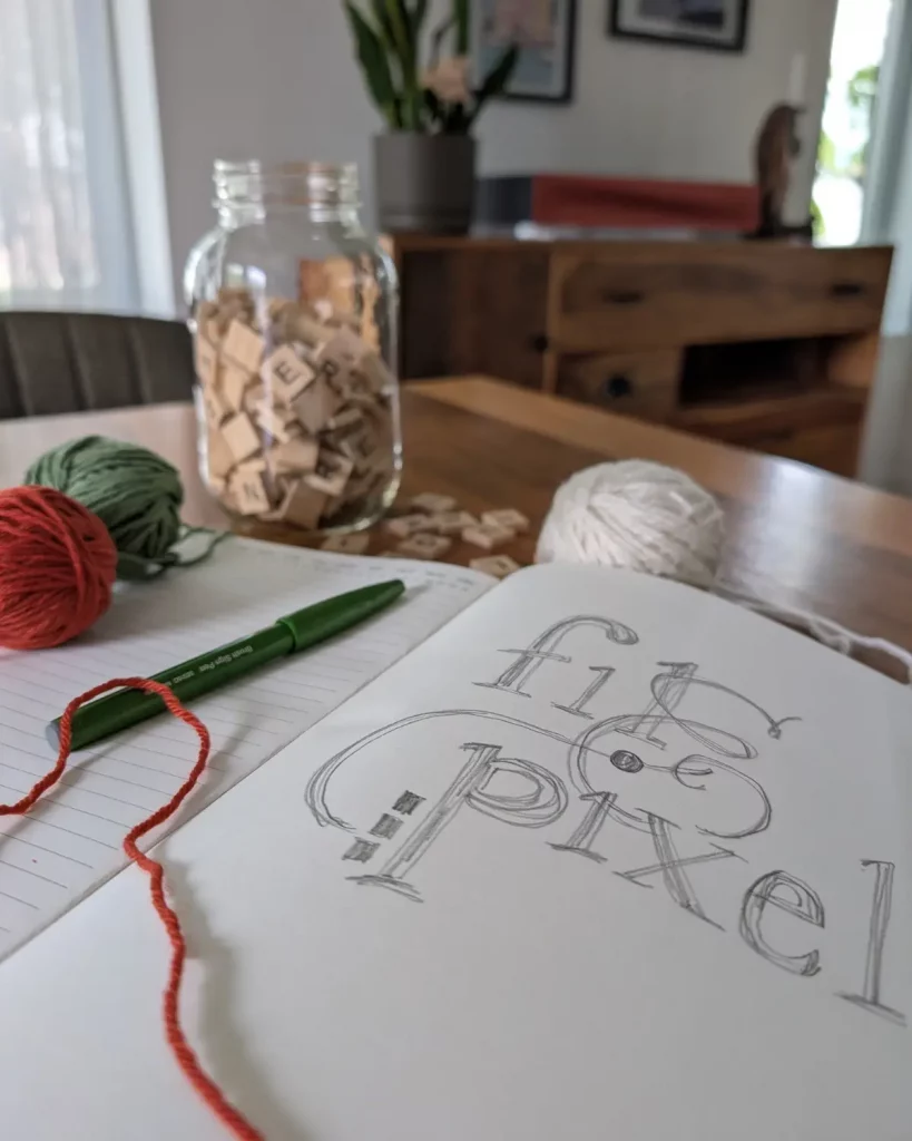 Cahier de notes, lettres de Scrabble et éléments créatifs illustrant l'accompagnement stratégique de Fil&Pixel.